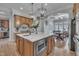 Gourmet kitchen featuring a large marble island with a sink and stainless steel appliances and pendant lights at 601 Ballad Creek Ct, Cary, NC 27519
