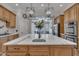 A kitchen with an island with marble countertops, wood cabinets, and stainless-steel appliances at 601 Ballad Creek Ct, Cary, NC 27519