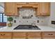 Well-equipped kitchen with stone countertops, stainless gas range, and designer backsplash at 601 Ballad Creek Ct, Cary, NC 27519