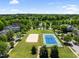 Aerial view showcases tennis and volleyball courts, a lake, and lush landscaping for active community living at 601 Ballad Creek Ct, Cary, NC 27519