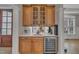 Elegant wet bar with wood cabinets, wine fridge, and ample storage for glassware and accessories at 601 Ballad Creek Ct, Cary, NC 27519