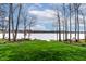 Lush green lawn with mature trees leads to a private dock on the serene lake at 651 Sagamore Dr, Louisburg, NC 27549