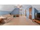 Large bonus room with blue walls, neutral carpet and a glimpse of lake through picture window at 651 Sagamore Dr, Louisburg, NC 27549