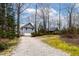 View of home from gravel driveway showing two-car garage and spacious outdoor area at 651 Sagamore Dr, Louisburg, NC 27549