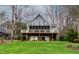 Backyard exterior of a two-story home with a screened porch overlooking the yard and lake at 651 Sagamore Dr, Louisburg, NC 27549