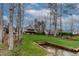 Exterior shot of the backyard, sloping green lawn, and lake view of a two-story home at 651 Sagamore Dr, Louisburg, NC 27549