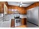 Galley kitchen features a stainless steel refrigerator and oven, wood cabinetry, and tiled backsplash at 651 Sagamore Dr, Louisburg, NC 27549