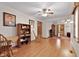 Open living room with wood floors, bookcase, rocking chair, and doorway to another room at 651 Sagamore Dr, Louisburg, NC 27549