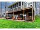 Spacious outdoor patio with seating and brick exterior and an upper screened-in porch above at 651 Sagamore Dr, Louisburg, NC 27549