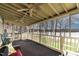 Cozy screened porch with ceiling fans, outdoor furniture, and serene lake views at 651 Sagamore Dr, Louisburg, NC 27549