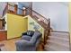 Stairway with carpet treads, natural wood railing, and a cozy chair sitting near the base at 651 Sagamore Dr, Louisburg, NC 27549