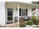 Inviting front porch with seating, decorative plants, and the house number clearly visible at 6923 Fox Haven Pl, Raleigh, NC 27616