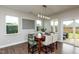 Open dining area features backyard views, modern lighting, and stylish seating for Gathering meals and entertaining at 709 Teal Lake Dr, Holly Springs, NC 27540