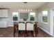 Dining room with a stylish table, chairs, and large windows providing natural light and views of the backyard at 709 Teal Lake Dr, Holly Springs, NC 27540
