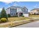 Charming two-story home featuring blue siding, a well-manicured lawn, and a two-car garage at 709 Teal Lake Dr, Holly Springs, NC 27540