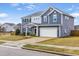 Two-story home featuring blue siding, a well-manicured lawn, and a two-car garage at 709 Teal Lake Dr, Holly Springs, NC 27540