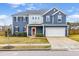 Charming two-story home featuring blue siding, a well-manicured lawn, and a two-car garage at 709 Teal Lake Dr, Holly Springs, NC 27540
