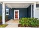 Inviting front porch with a red door, manicured shrubs, and a warm welcome mat at 709 Teal Lake Dr, Holly Springs, NC 27540