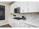 Modern kitchen featuring white cabinets, stainless steel appliances, and granite countertops at 709 Teal Lake Dr, Holly Springs, NC 27540