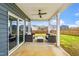 Covered patio with comfortable seating, ceiling fan, and views of the landscaped backyard at 709 Teal Lake Dr, Holly Springs, NC 27540