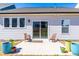 Back patio with sliding glass doors, two wooden chairs, and vibrant potted plants at 74 Silver Moon Ln, Clayton, NC 27527