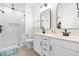 Stylish bathroom with double vanity, framed mirrors, sleek fixtures, and a glass-enclosed shower at 74 Silver Moon Ln, Clayton, NC 27527