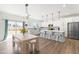 Bright dining area features modern lighting, a wood table with bench seating, and access to the backyard at 74 Silver Moon Ln, Clayton, NC 27527