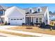 Inviting single-Gathering home featuring a covered porch and an attached two-car garage at 74 Silver Moon Ln, Clayton, NC 27527