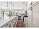 Stylish kitchen featuring sleek white cabinets, modern appliances, a long center island, and hardwood flooring at 74 Silver Moon Ln, Clayton, NC 27527