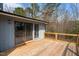 Relaxing wooden deck features a sliding glass door entry, black metal railings, and wooded backyard views at 75 Traceway N, Sanford, NC 27332
