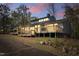Twilight view showcasing a large wooden deck, neutral siding, and a sloped backyard at 75 Traceway N, Sanford, NC 27332