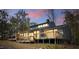 Exterior view showcasing a wooden deck with railing and gray siding and a view of the sunset in the background at 75 Traceway N, Sanford, NC 27332