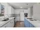 Bright kitchen featuring white cabinetry, stainless appliances, and island cooktop at 75 Traceway N, Sanford, NC 27332