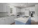Bright kitchen featuring white cabinetry, stainless appliances, and island cooktop at 75 Traceway N, Sanford, NC 27332