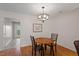 Dining area with a wooden table and chairs, featuring an elegant chandelier for a warm ambiance at 7914 Yester Ct, Raleigh, NC 27615