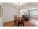 Inviting dining area featuring a modern chandelier and hardwood floors that flow into a comfortable living space at 7914 Yester Ct, Raleigh, NC 27615