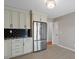 Contemporary kitchen featuring stainless steel appliances, contrasting backsplash, and ample cabinet space for storage at 7914 Yester Ct, Raleigh, NC 27615