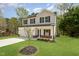Charming two-story home with a well-manicured lawn, attached garage, and beautiful landscaping at 804 E D St, Butner, NC 27509