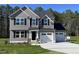 Charming two-story home featuring gray siding, black shutters, a two-car garage, and a well-manicured front lawn at 95 Tulipfield Way, Benson, NC 27504