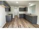 Well-lit kitchen featuring gray cabinets, granite countertops, modern appliances, and wood-look vinyl flooring at 95 Tulipfield Way, Benson, NC 27504