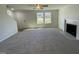 Inviting living room featuring neutral carpeting, a fireplace, and abundant natural light from large windows at 95 Tulipfield Way, Benson, NC 27504
