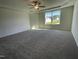 Bright main bedroom features a ceiling fan, tray ceiling, plush carpeting, and ample natural light from the large window at 95 Tulipfield Way, Benson, NC 27504