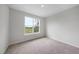 This bedroom features neutral carpet, light gray walls, and a bright window at 96 Ripple Way # 316, Clayton, NC 27520