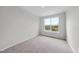 This bedroom features neutral carpet, light gray walls, and a bright window at 96 Ripple Way # 316, Clayton, NC 27520