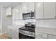 Modern kitchen showcasing stainless steel oven and microwave over quartz countertops and subway tile at 96 Ripple Way # 316, Clayton, NC 27520