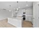 Open kitchen with stainless steel appliances, white cabinetry, island, and pendant lighting at 96 Ripple Way # 316, Clayton, NC 27520