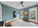 Bright bonus room featuring wood floors, a ceiling fan, and an exercise machine with blue accent walls at 1001 Hazeltown Rd, Wake Forest, NC 27587