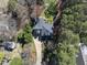 An aerial view of a tree-lined property featuring a well-maintained house with a driveway and landscaped grounds at 1006 Henny Pl, Raleigh, NC 27614