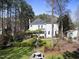 Expansive backyard featuring a white two-story house with an outdoor pergola, manicured landscaping, and a water fountain at 1006 Henny Pl, Raleigh, NC 27614