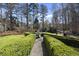 An outdoor garden space features manicured hedgerows, a stone water fountain, and a gravel walkway at 1006 Henny Pl, Raleigh, NC 27614